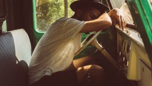 A young man sleeping in a truck he has hired for moving out of Florida.