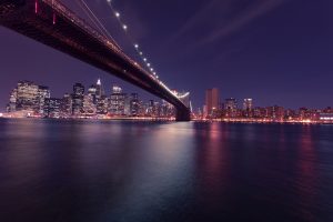 A view of the Brooklyn Bridge and NY by night.