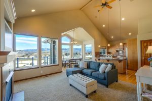 A home with a big and specious living room with lots of natural light and big windows.