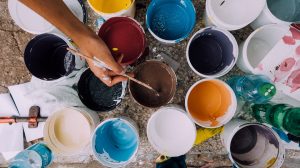 A lot of buckets with various types of paint.