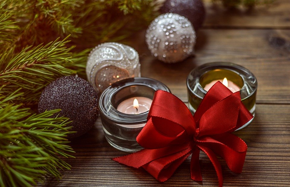 Two little candles in the middle of a table with other decorations.