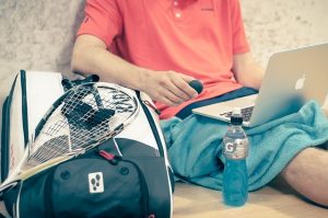 Man with laptop and training gear.
