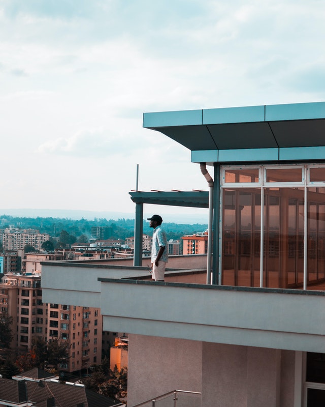 Man on the balcony thinking about buying a property overseas in 2020