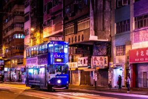 A blue double-decker bus in the street.