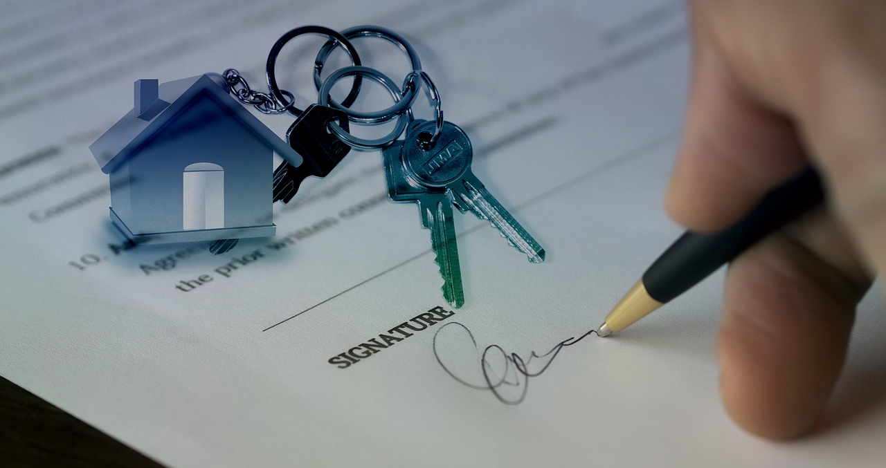 A person signing a contract and getting the house keys once he manages to buy a property in Kuwait as a foreigner