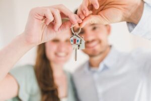 A couple holding some house keys.