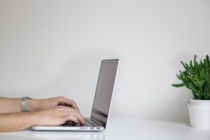 A person using a lap top to do research about house hunting in Florida.