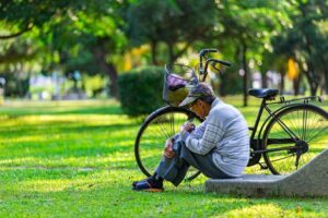 A man with a bike in a park.