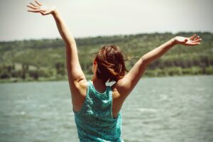 a happy young girl raising her arms.