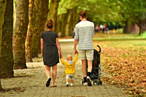 Parents walking their child in a park in one of the Columbus neighborhoods.