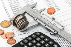 A pile of coins squeezed together and a black calculator.